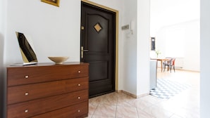 Quarto com penteadeira de madeira, porta preta e chão quadriculado.