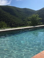 Una piscina al aire libre de temporada, sillones reclinables de piscina