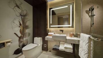 A modern bathroom with a toilet, sink, and shower.