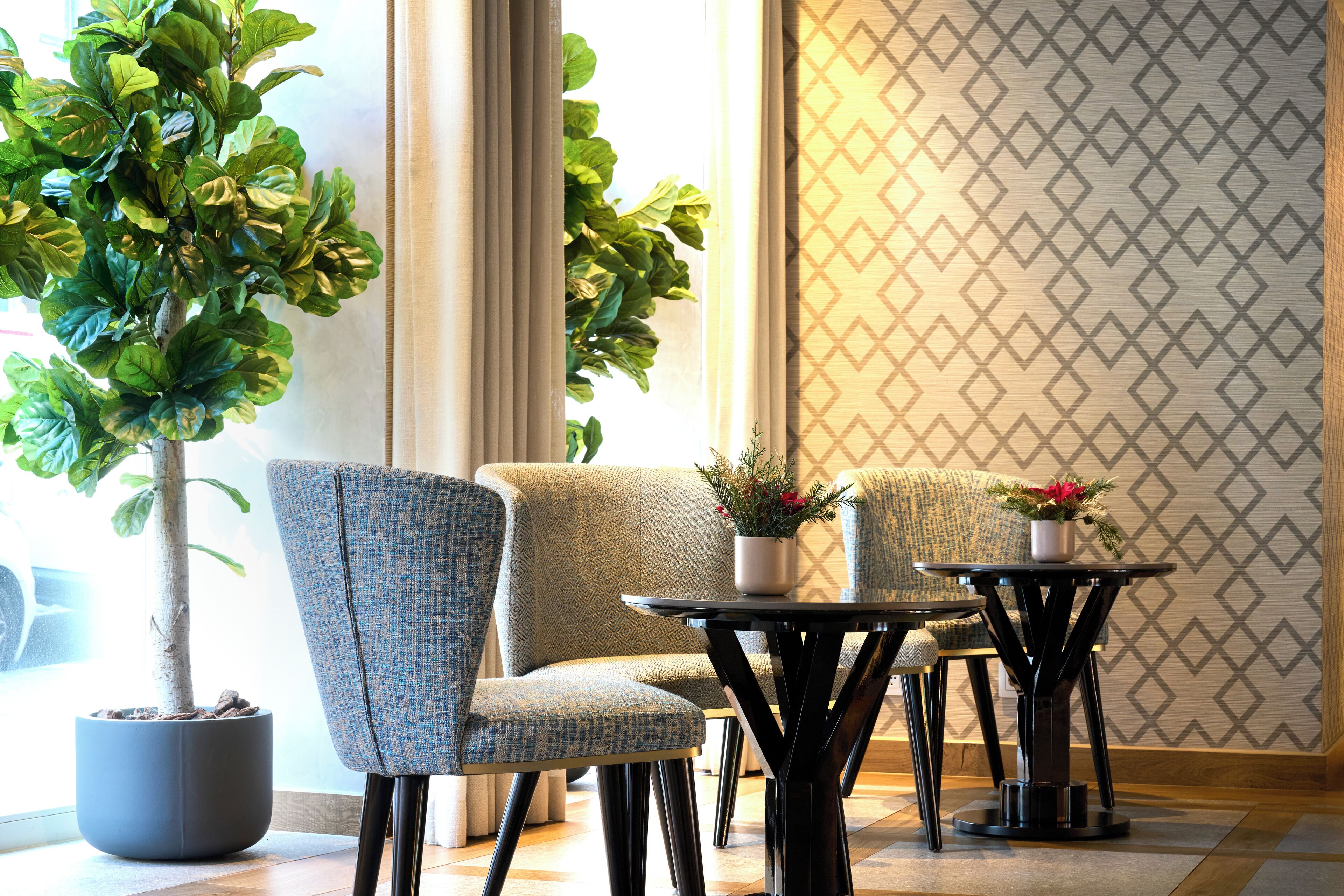 Eine Sitzecke mit einem Blumentopf, zwei Stühlen und einem kleinen Tisch.