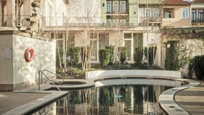 A swimming pool with a lifebuoy, surrounded by buildings and trees.