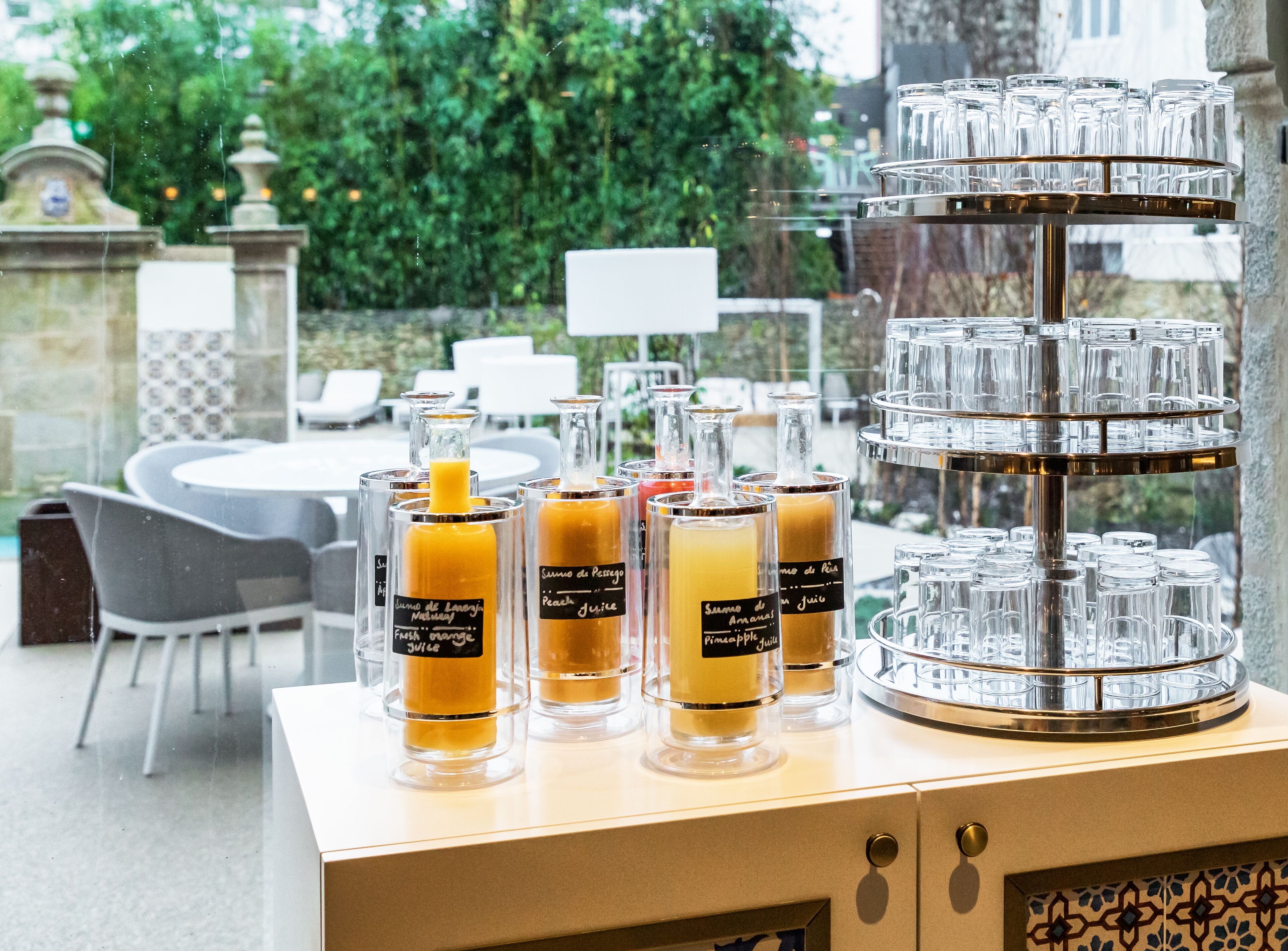 A buffet table with various juices and a glassware display.