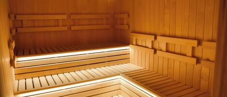 A sauna with multiple benches and a wooden interior.