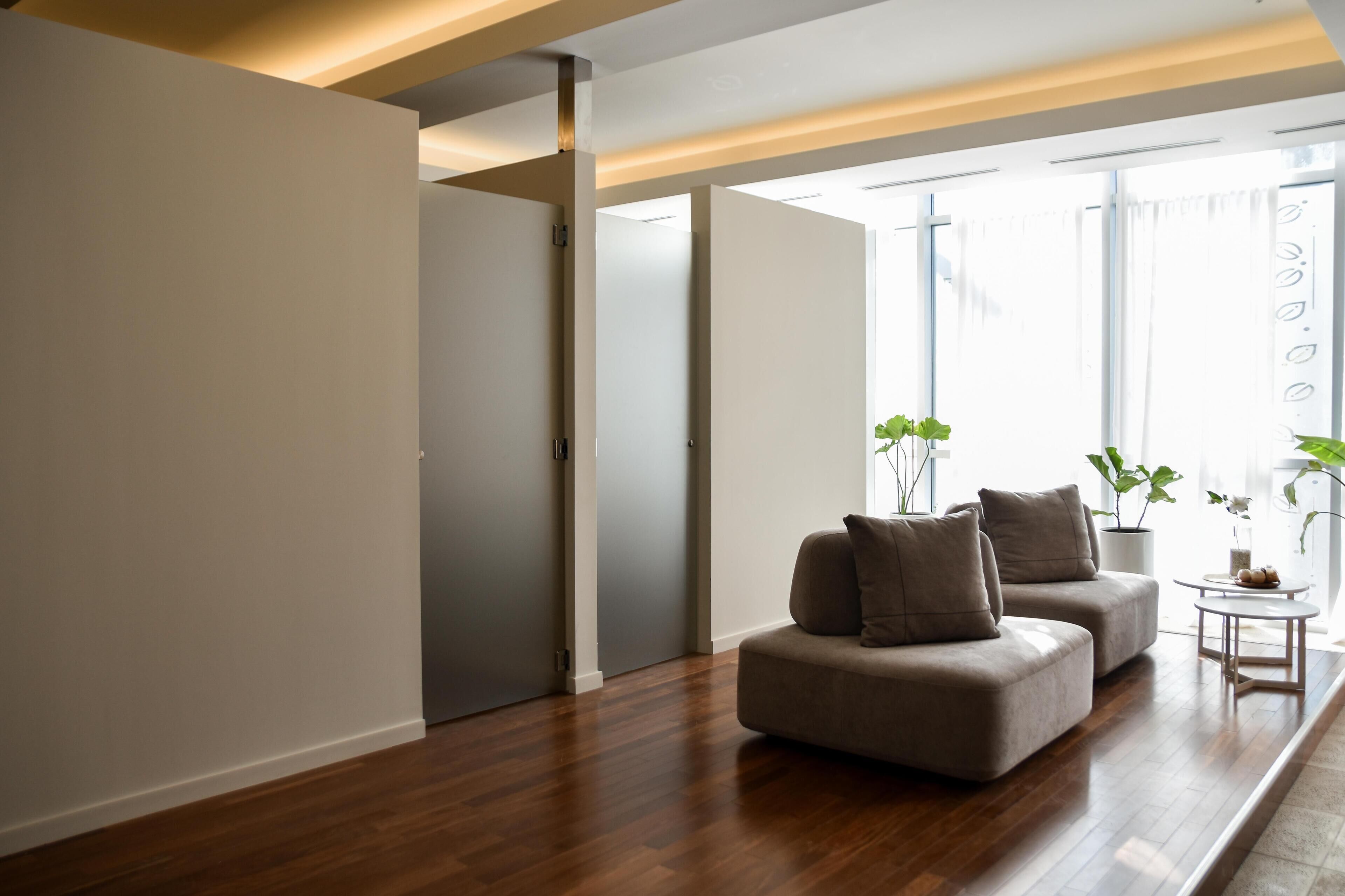 A modern living room with a sofa set, a coffee table, and potted plants.