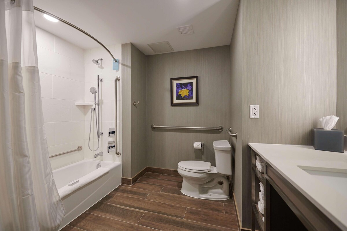 A bathroom with a shower, toilet, and sink.