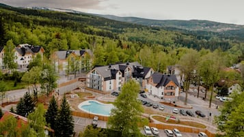 A residential area with multiple houses, a swimming pool, and a parking lot.