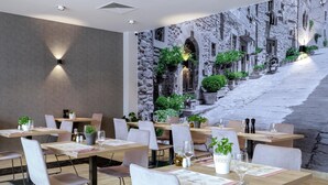 A restaurant with tables set for dining, a stone wall mural, and potted plants. - Green Apartments (Karpacz)