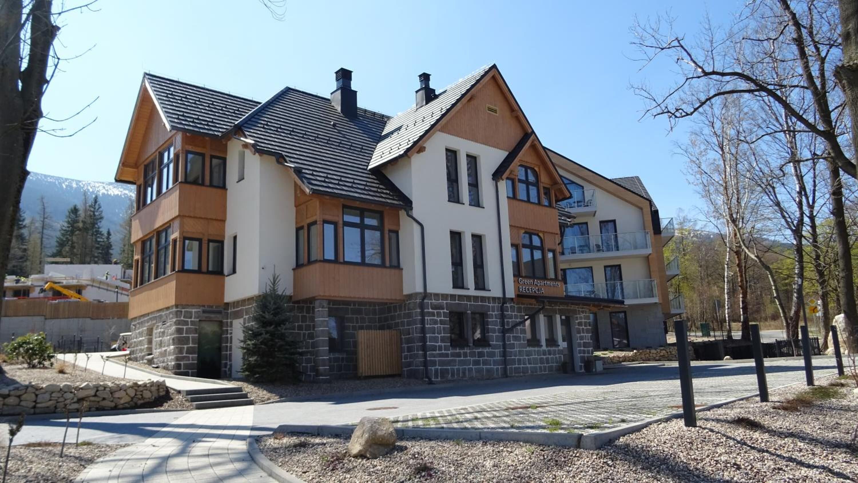 A multi-story building with a stone foundation, large windows, and a flat roof.