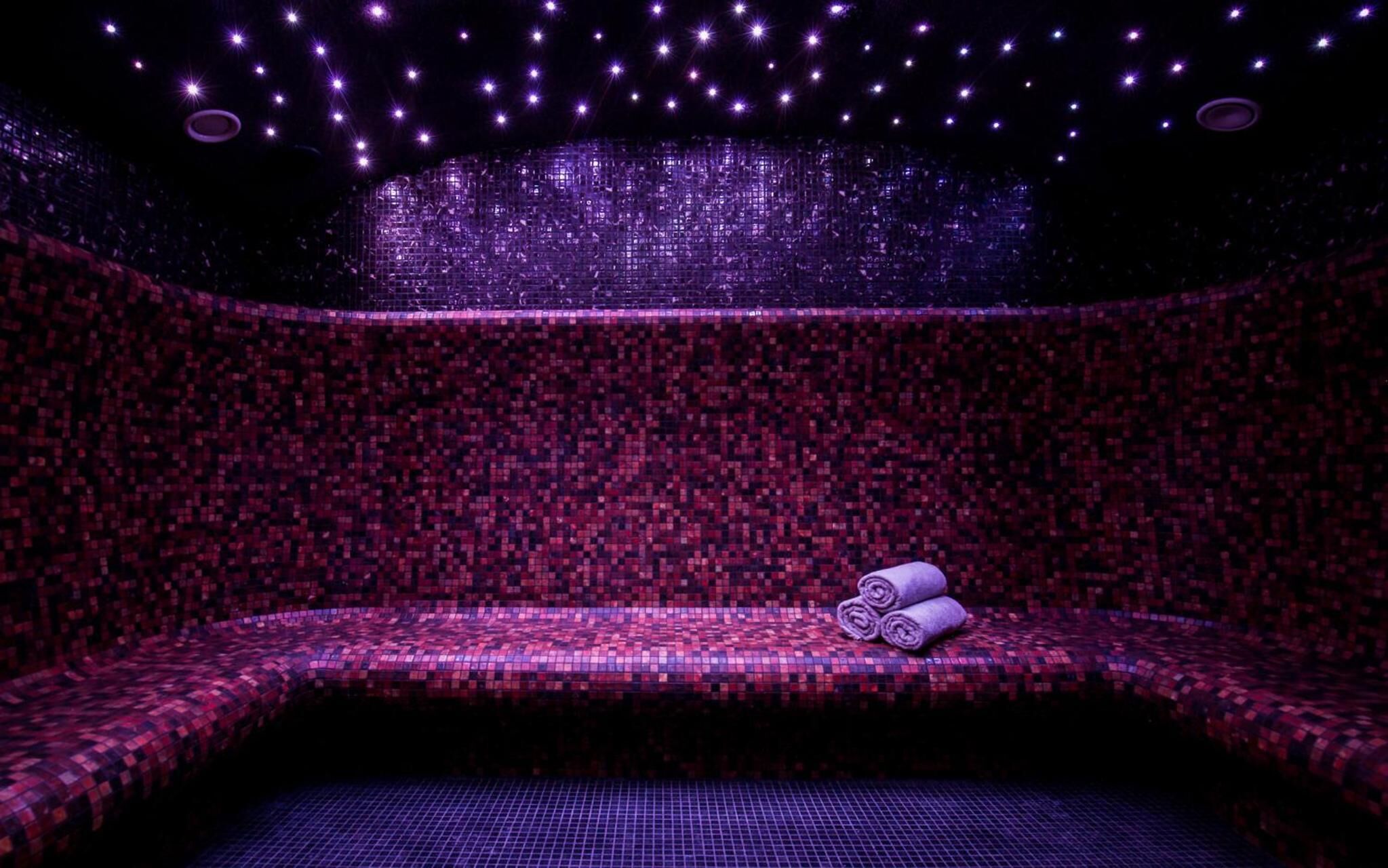 Une salle de spa avec un banc à motifs et une serviette.