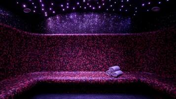 Une salle de spa avec un banc à motifs et une serviette.