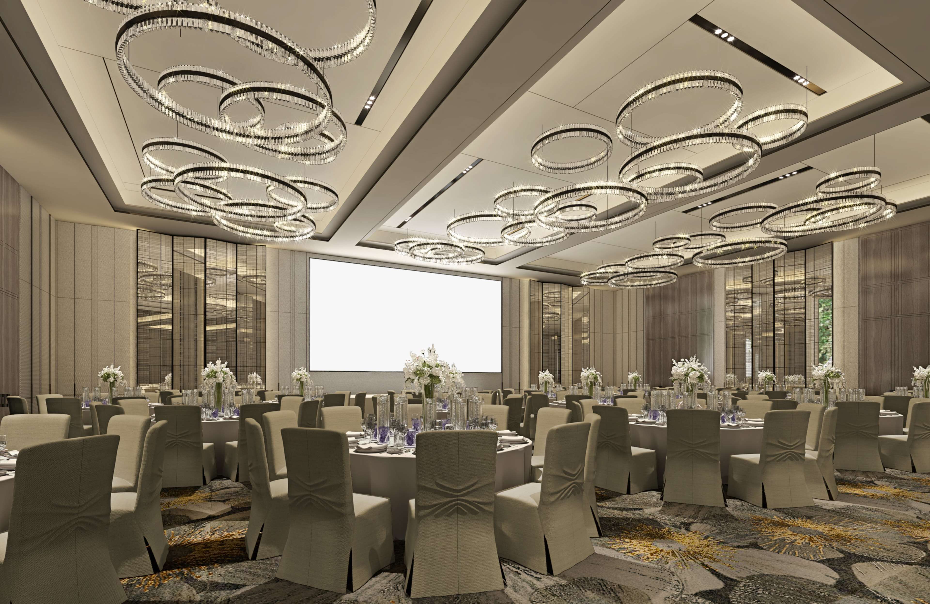 A conference room with round tables, beige chairs, and a large screen.
