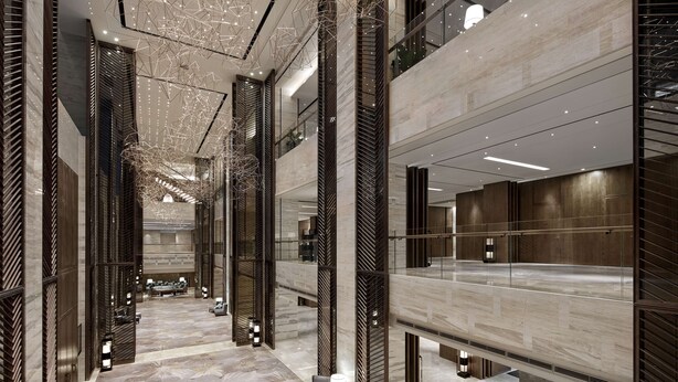 Um hall amplo com pé-direito alto, iluminação moderna e piso de mármore.