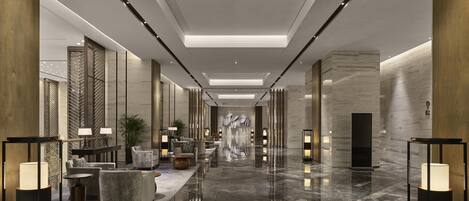 A modern lobby with a marble floor, seating areas, and ambient lighting.