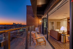 Enjoy a city view from the balcony, featuring a seating area with a sofa and armchairs.