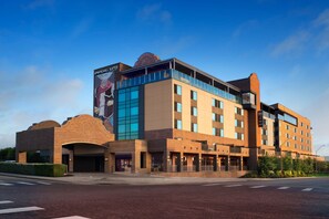 Situated at a street corner, this hotel features a distinctive arched entrance and a rooftop structure.