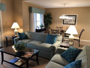 Relax in this stylish living room with a sofa set, coffee table, and dining area.