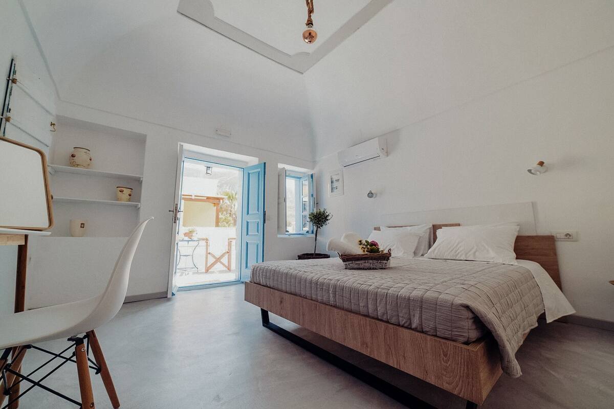 Ein Schlafzimmer mit Bett, Schreibtisch, Stuhl und einem kleinen Tisch.