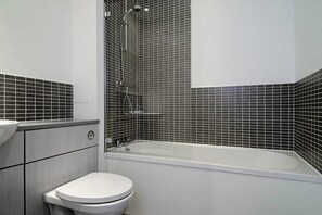 A bathroom with a white toilet, a bathtub, and a shower. - Fabulous Apartment near Edinburgh Center (Edinburgh)