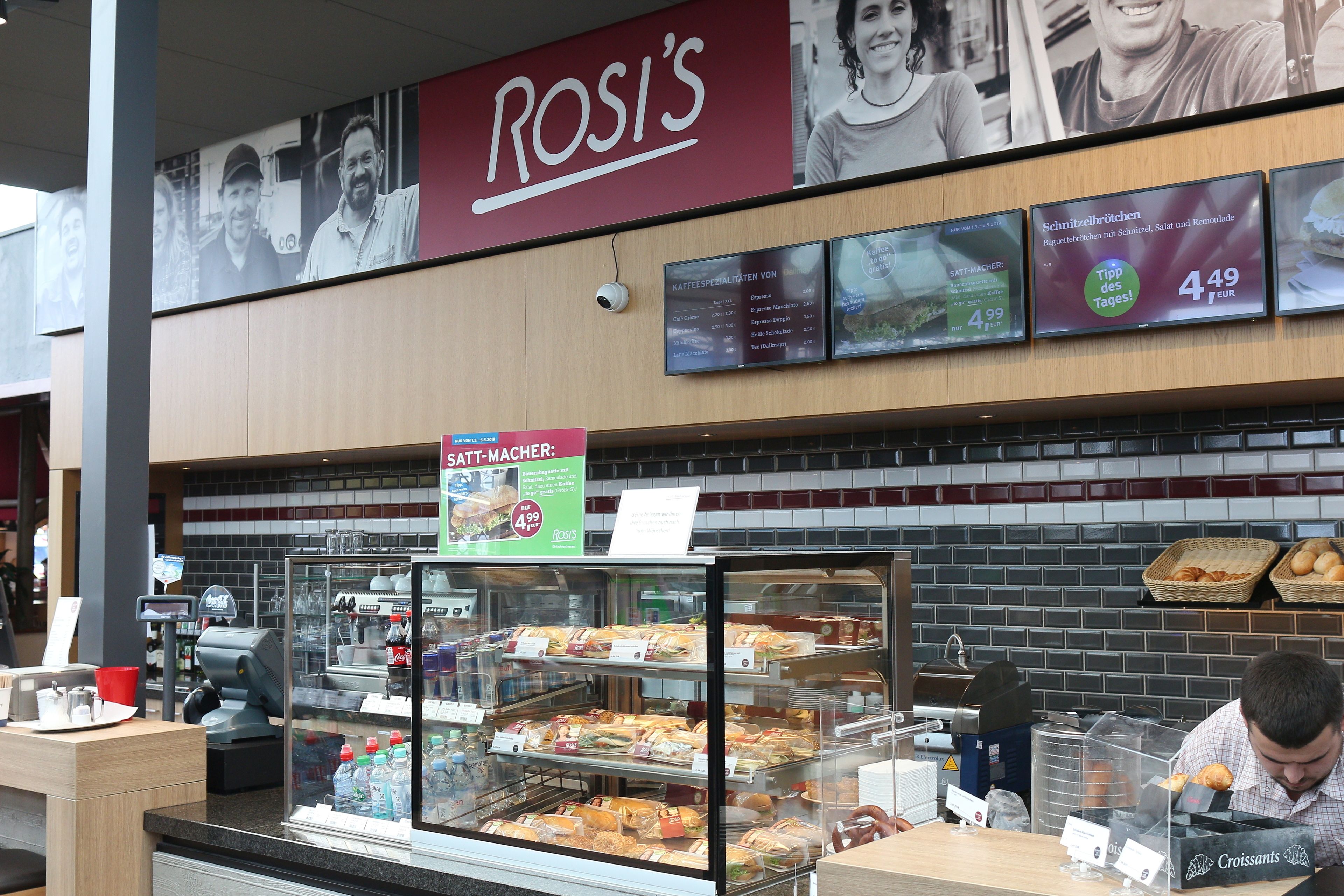 A deli counter with a menu board displaying prices and items.