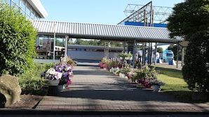 A gas station with a covered canopy, potted plants, and a blue truck parked nearby. - Autohof & Hotel Salzbergen (Salzbergen)