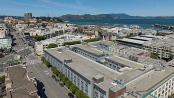 An aerial view of a cityscape with a prominent building featuring a flat roof and multiple windows.