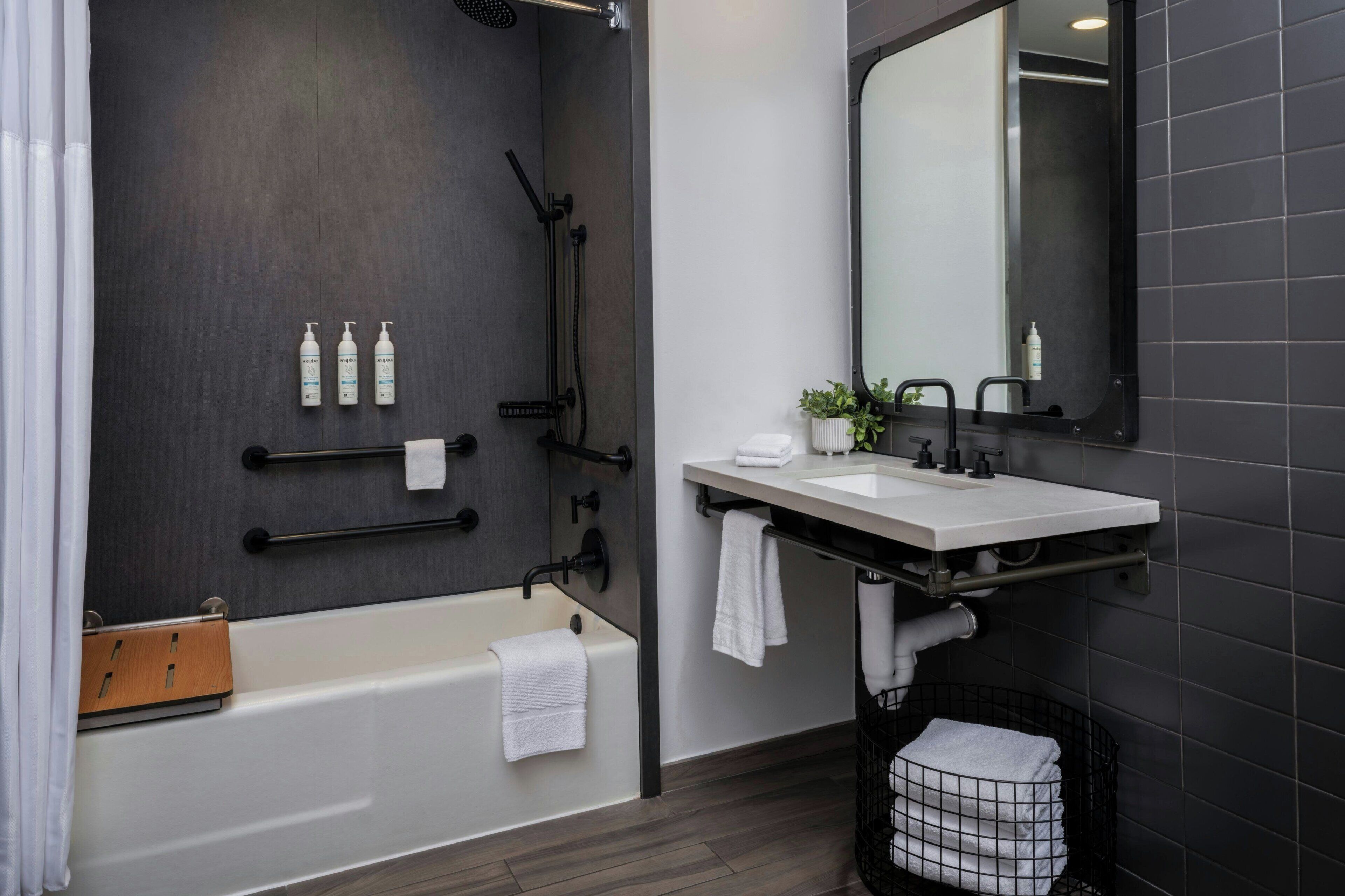 Un baño moderno con bañera, lavamanos y zona de ducha.