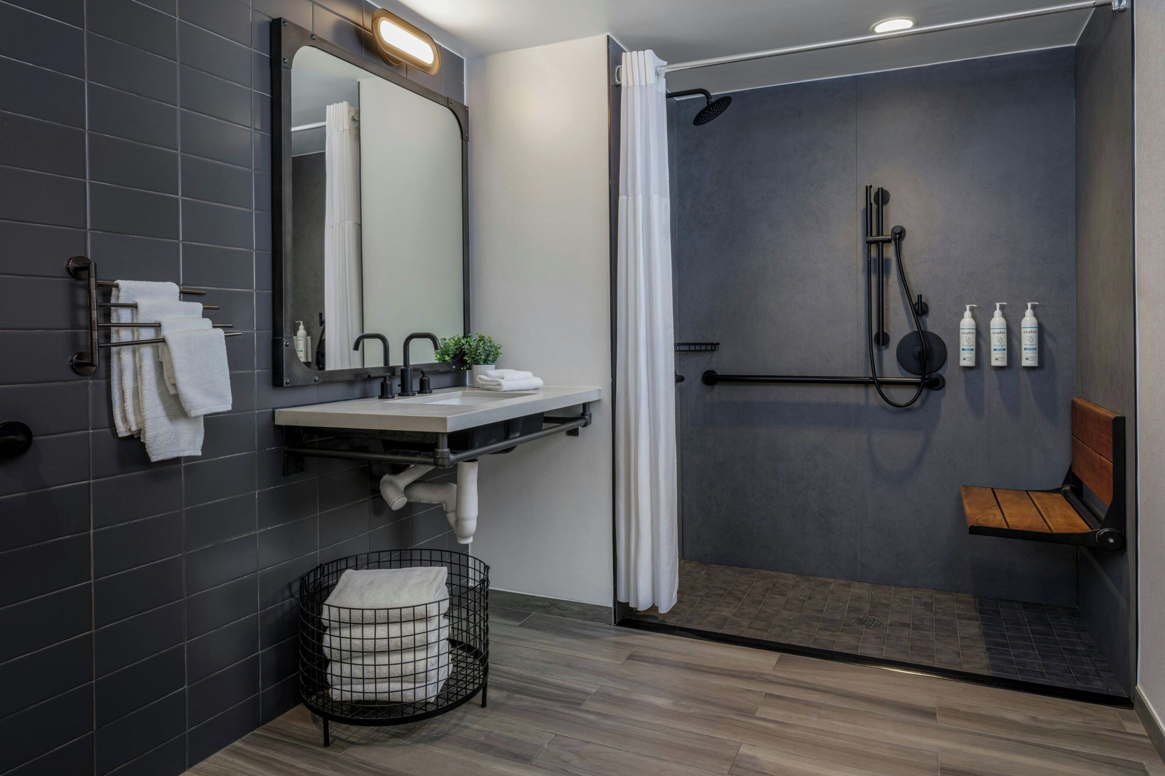 A modern bathroom with a shower, a sink, and a mirror.