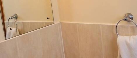A bathroom with a white sink, a mirror, and a towel rack.