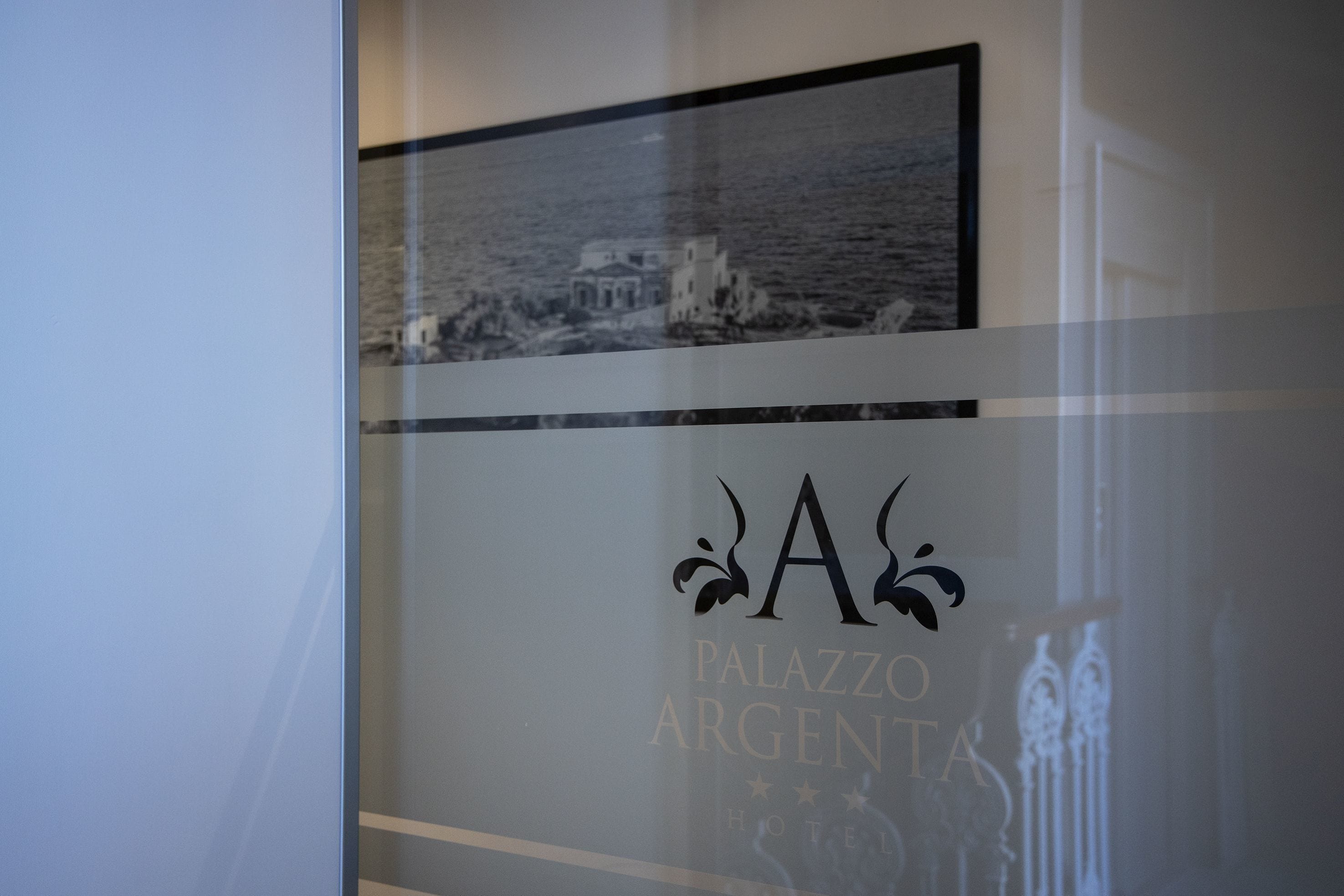 Ein Hotelschild mit dem Namen "PALAZZO ARGENTA" und einem Logo.