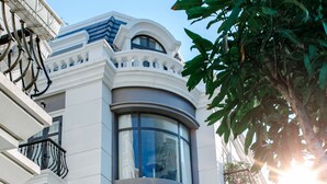 A modern building with a curved facade, large windows, and balconies with railings. - The Oriental Ruby (Dong Hoi)