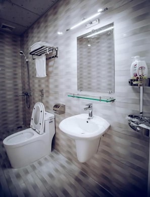 A modern bathroom with a toilet, bidet, and sink.