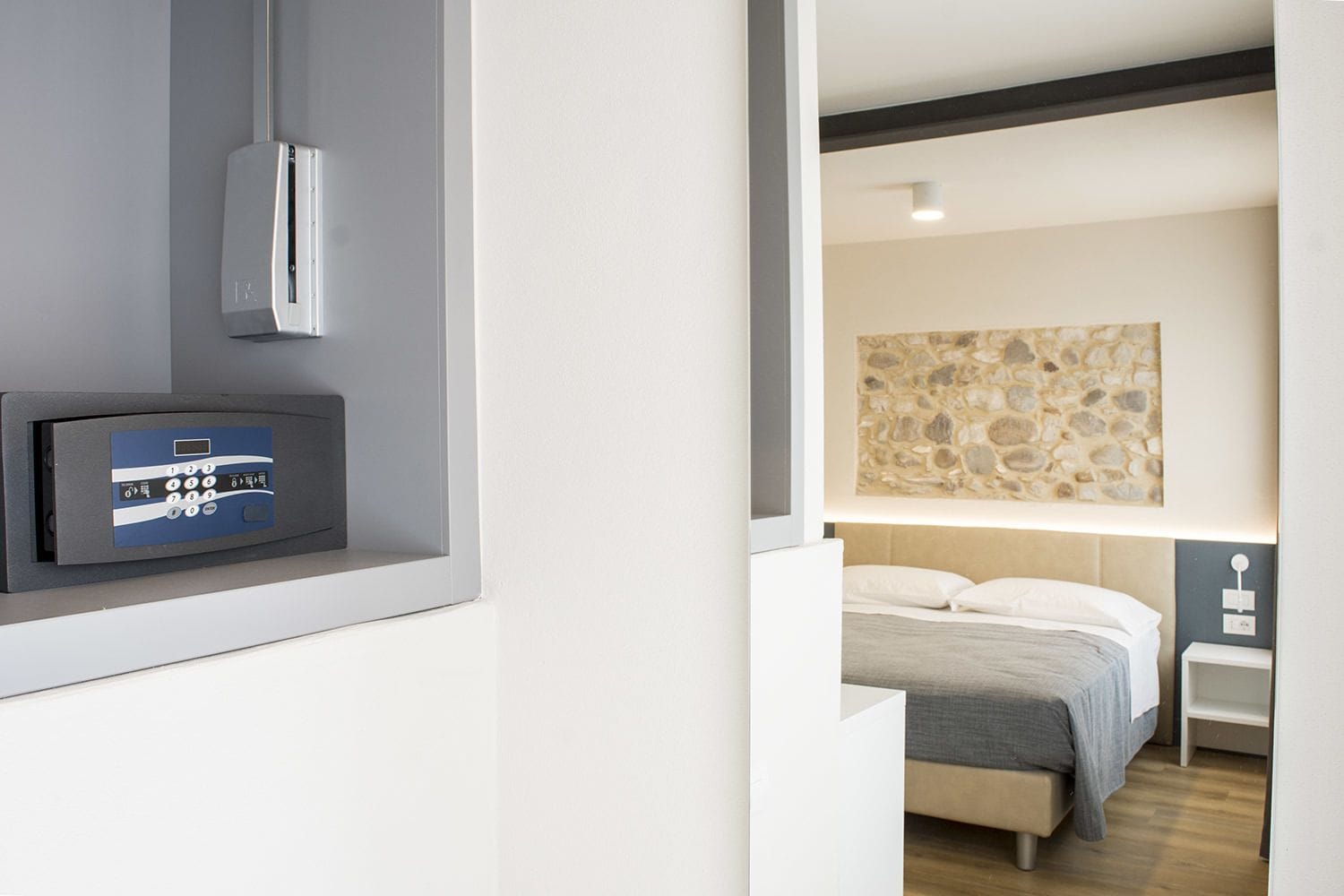Une chambre d’hôtel moderne équipée d’un lit, d’une table de chevet, d’une œuvre d’art accrochée au mur et d’un panneau de commande.