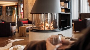 A cozy living room with a modern fireplace, leather sofas, and a wooden floor.