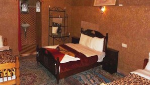 A bedroom with a wooden bed, a small table, a chair, and a decorative mirror. - Hostel take your time 4219 (Zagora)