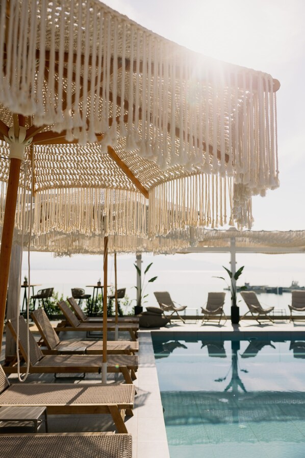 A poolside area with lounge chairs and a large pool.