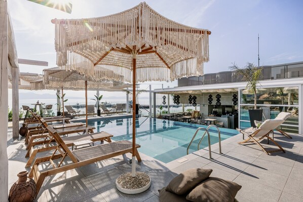 Outdoor pool, open 11:00 AM to 7:00 PM, pool umbrellas, pool loungers