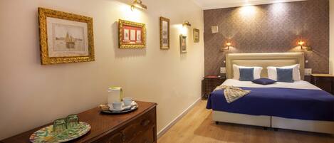 A hotel room with a bed, a dresser, and wall-mounted lights.
