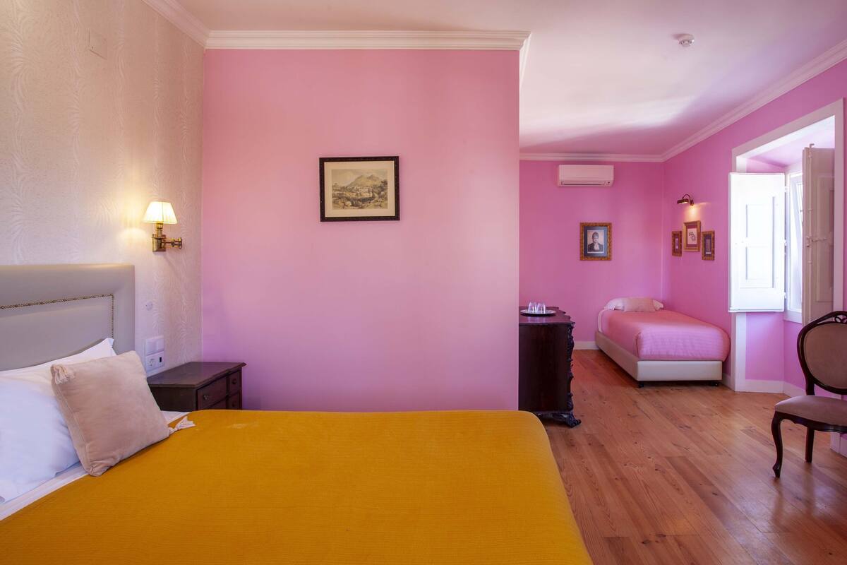 Ein Hotelzimmer mit Bett, Nachttisch, Lampe und einem Sessel.