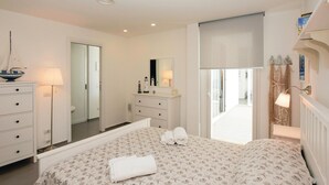 A bedroom with a bed, dresser, mirror, and a view of the outside. - Lovely apartment in Marina di Ragusa (Marina di Ragusa)