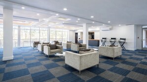 A spacious lobby with checkered carpet, multiple seating areas, and a view of the outdoors through large windows. - 1st Place Hotel Decatur I-20 East Atlanta (Decatur)