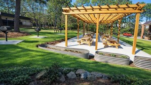 A covered picnic area with benches and tables, surrounded by a well-maintained lawn and trees. - 1st Place Hotel Decatur I-20 East Atlanta (Decatur)