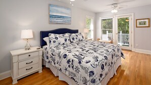 A bedroom with a bed, nightstand, and ceiling fan.