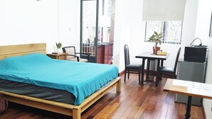 Een slaapkamer met een houten bed, een bureau, een stoel en een televisie.