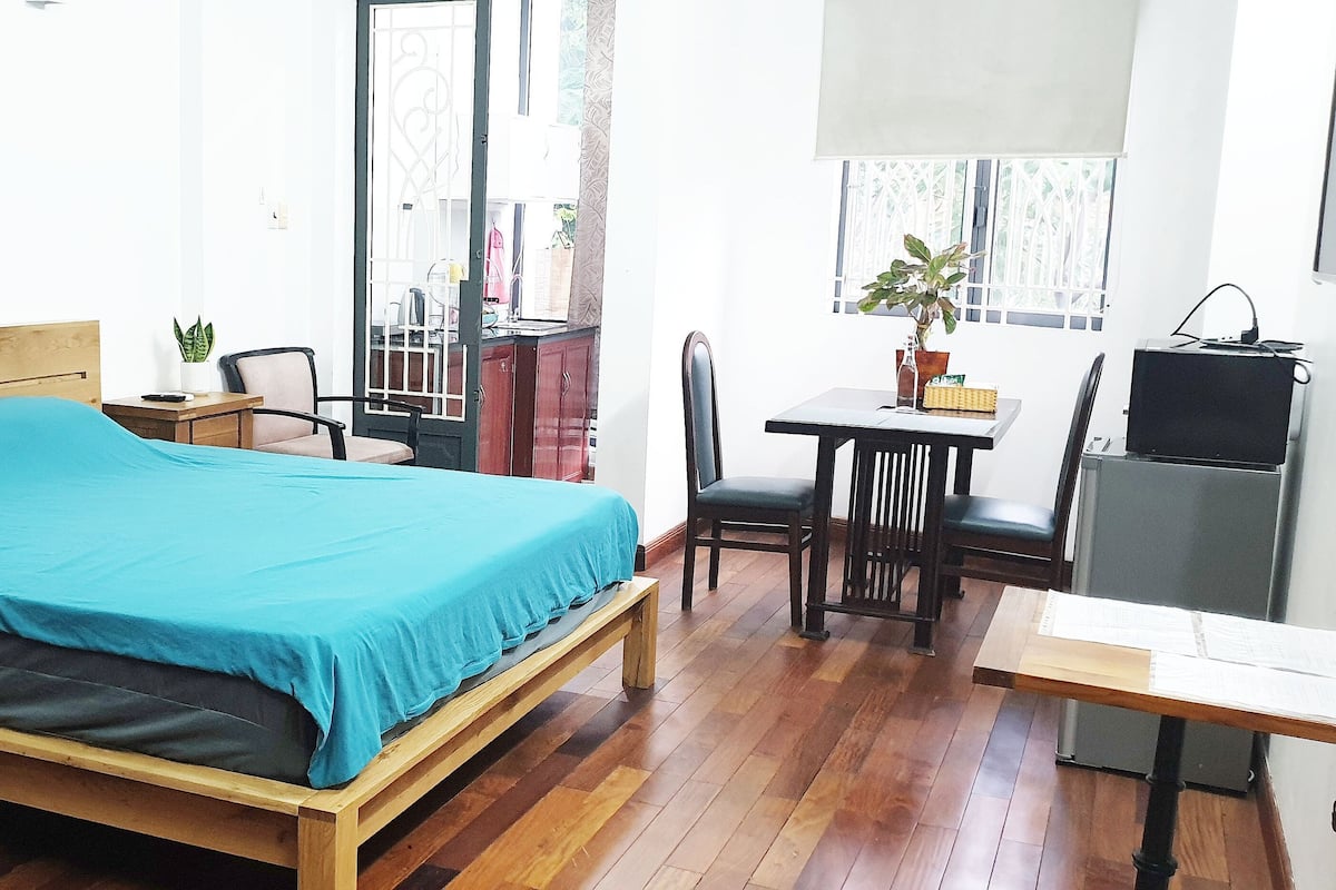 Un dormitorio con una cama de madera, un escritorio, una silla y un televisor.