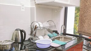 Een keuken met een gasfornuis, een spoelbak en houten keukenkastjes.