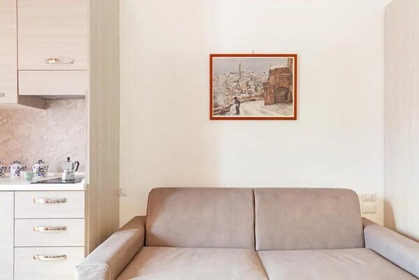 Ein sofas in neutralen Farbtönen in einem modernen Wohnzimmer mit einem gerahmten Stadtbild an der Wand.