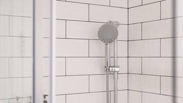 Eine moderne Dusche mit Regendusche und Handbrause, vor einer weißen Fliesenwand.