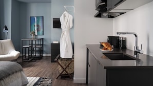 A modern kitchen with a sink, a coffee machine, and a croissant on the counter.