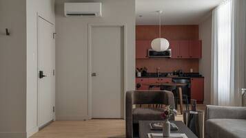 Una sala de estar moderna con una mesa de comedor, un sofá y una cocina al fondo.