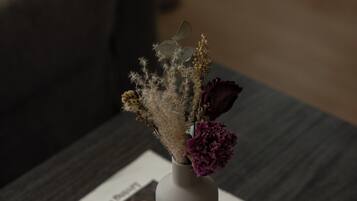 A vase with dried flowers on a table with a magazine.
